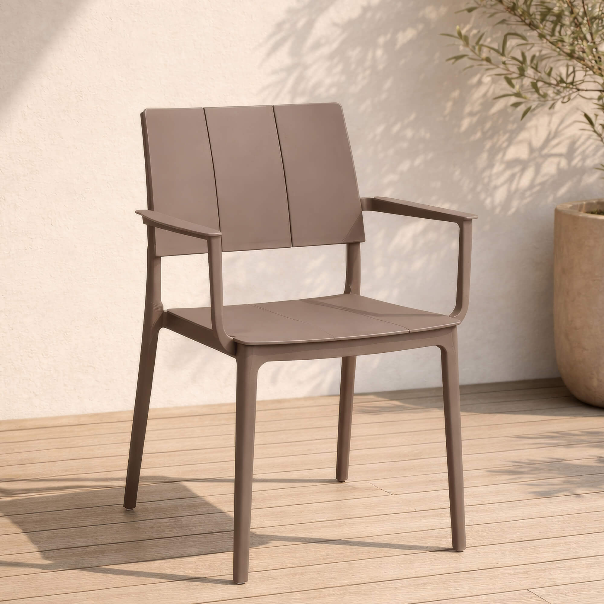 Outdoor Kunststoffstuhl Foma Taupe mit Armlehnen Outdoor Kunststoffstuhl Foma in Taupe mit Armlehnen auf Holzterrasse im warmen Außenbereich