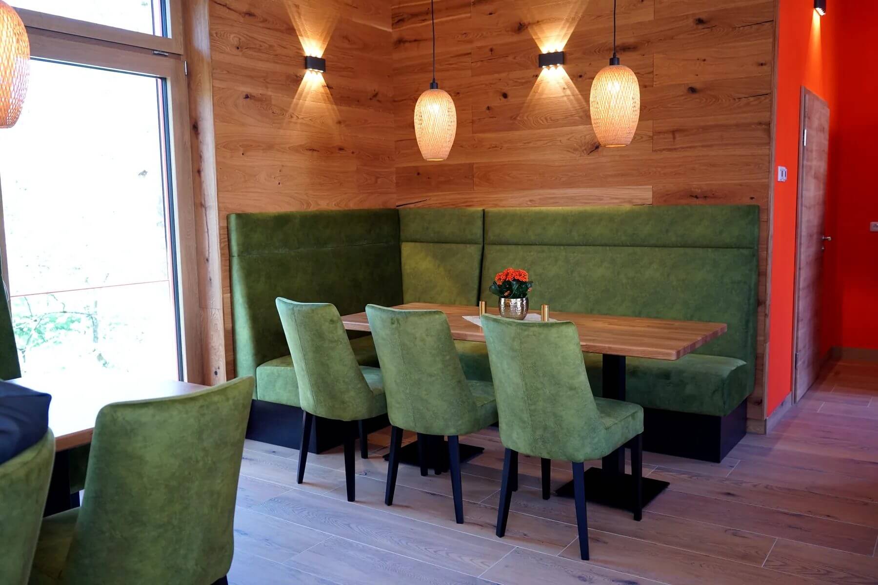 Gastraum mit gruenen Polsterstuehlen im Cafe Flow Gastraum im Cafe Flow mit gruenen Polsterstuehlen und Polsterbank an Holzwand