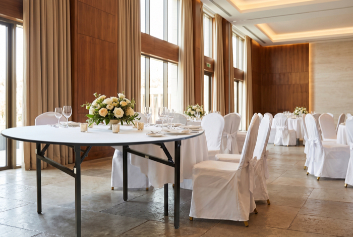 Banketttische mit weißen Stuhlhussen im Saal
