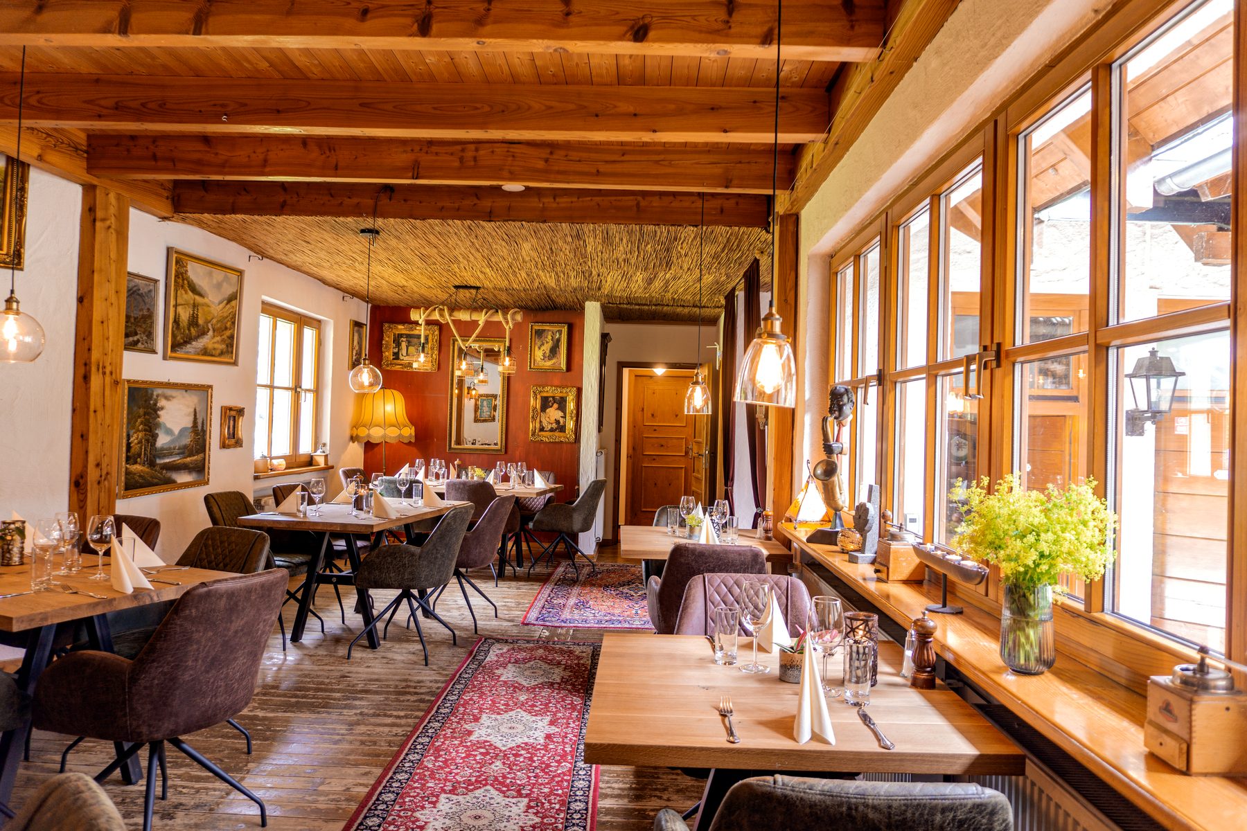 Fensterseite im Alten Wohnzimmer Fensterseite im Alten Wohnzimmer der Eifeler Seehütte mit Holztischen, Stühlen und gedeckten Plätzen