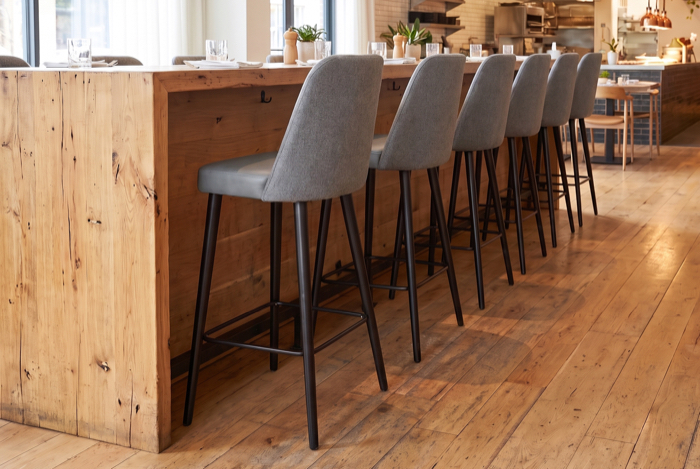 Gepolsterte Barhocker an einer Holztheke