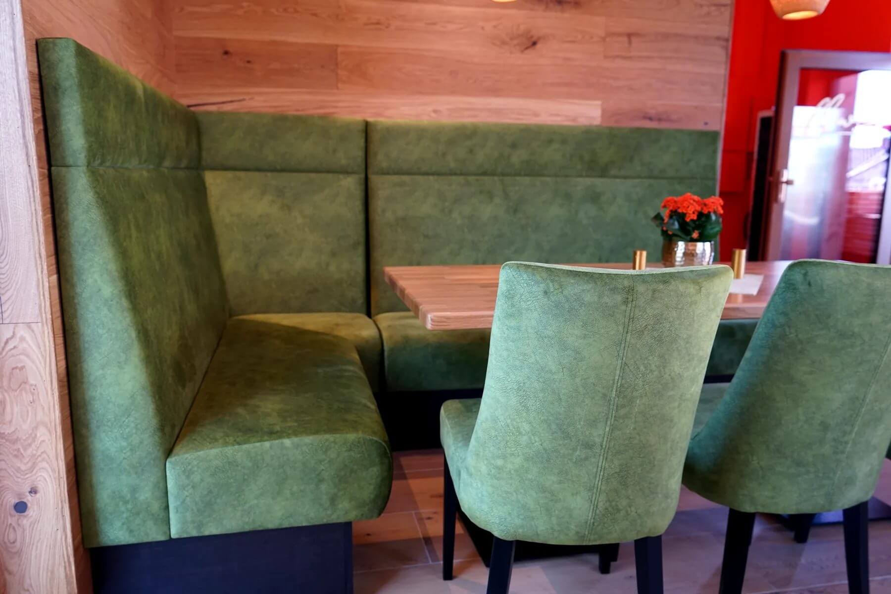 Sitznische im Cafe Flow mit gruener Polsterbank Q-101-s und Polsterstuehlen