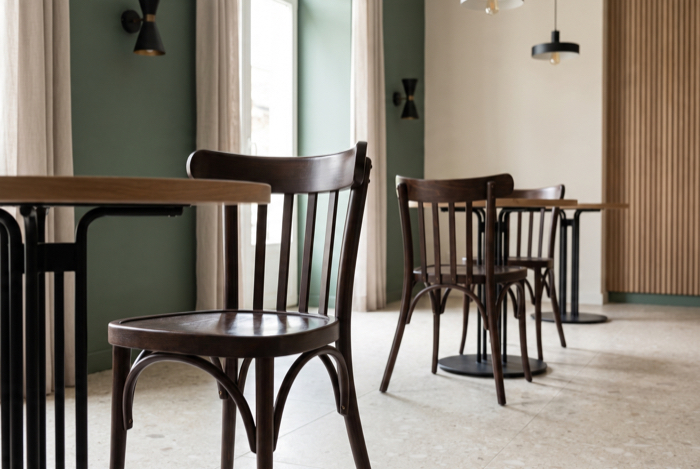 Bugholzstühle an Bistrotischen im Innenbereich