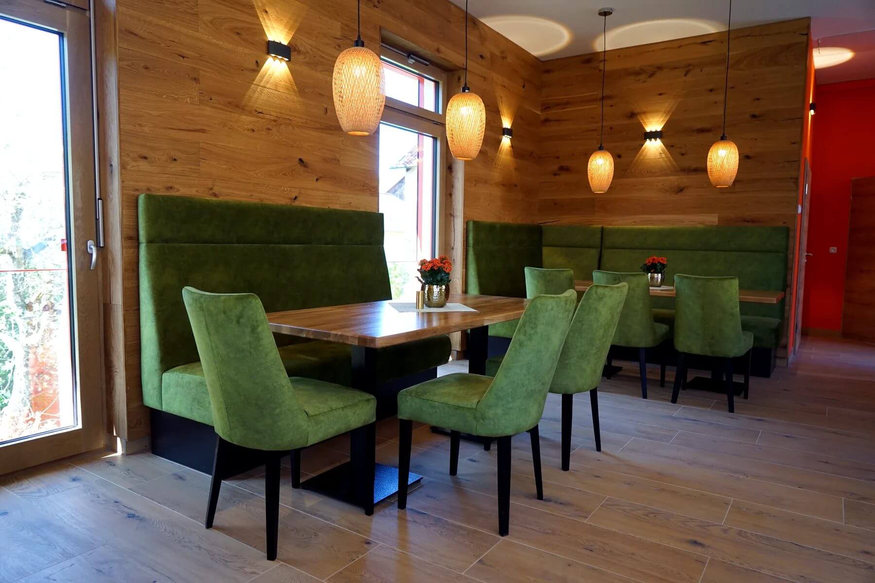 Gastronomieeinrichtung im Cafe Flow Marktgraitz Gastraum im Cafe Flow mit Polsterbank, Holztischen und gruenen Gastronomiestuehlen