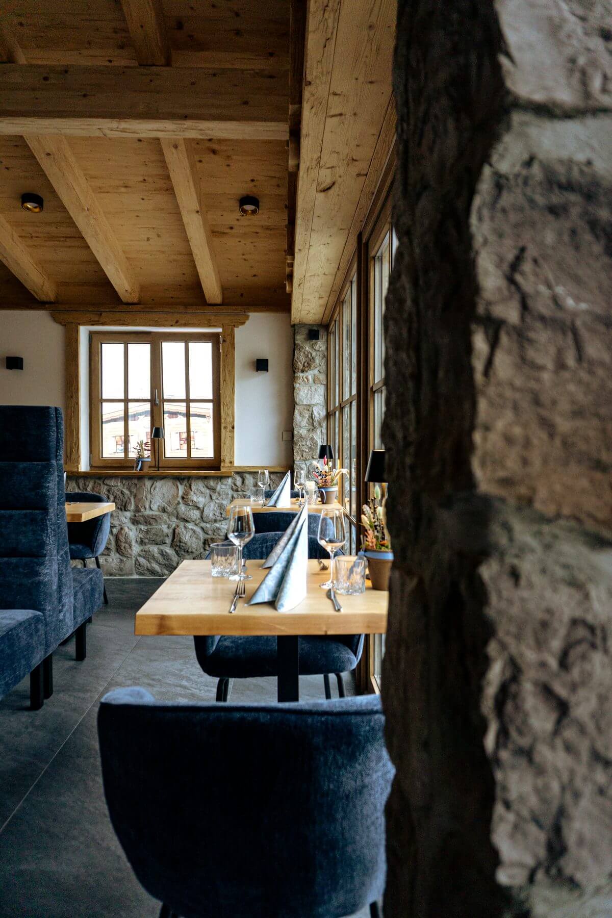 Sitznische im Restaurant Pfeiffer am Wörthsee mit Polsterbank, Tisch und Natursteinwand