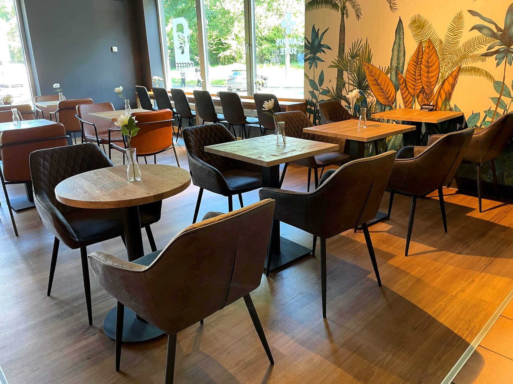 Gastraum mit Coffee-Fellows-Wandgestaltung Gastraum bei Coffee Fellows Campus Suite mit Tischgruppen, Stühlen und markanter Coffee-Fellows-Wandgestaltung