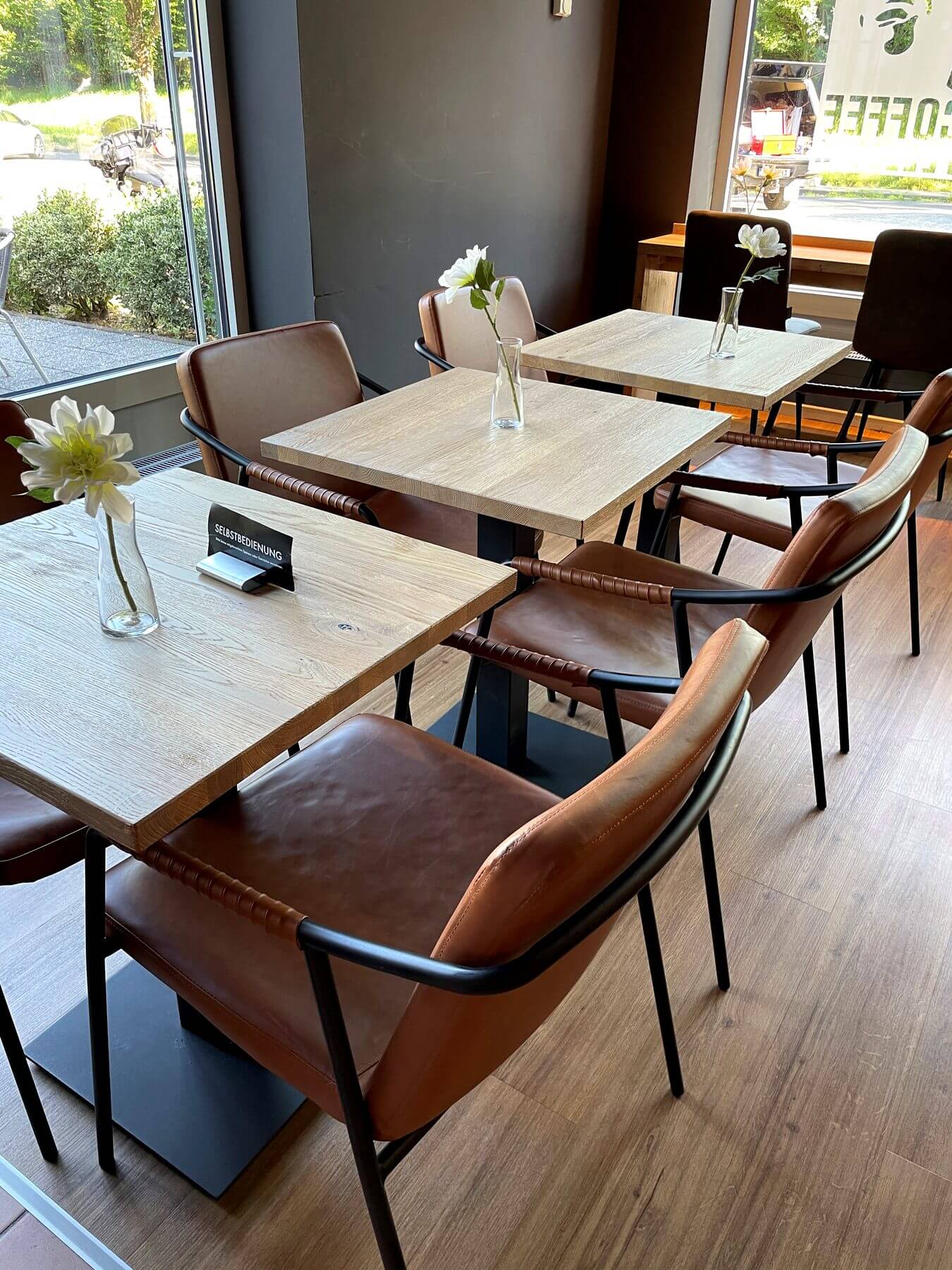 Detailansicht von Fara Arm brown Stühlen an hellen Tischen im Coffee Fellows Campus Suite
