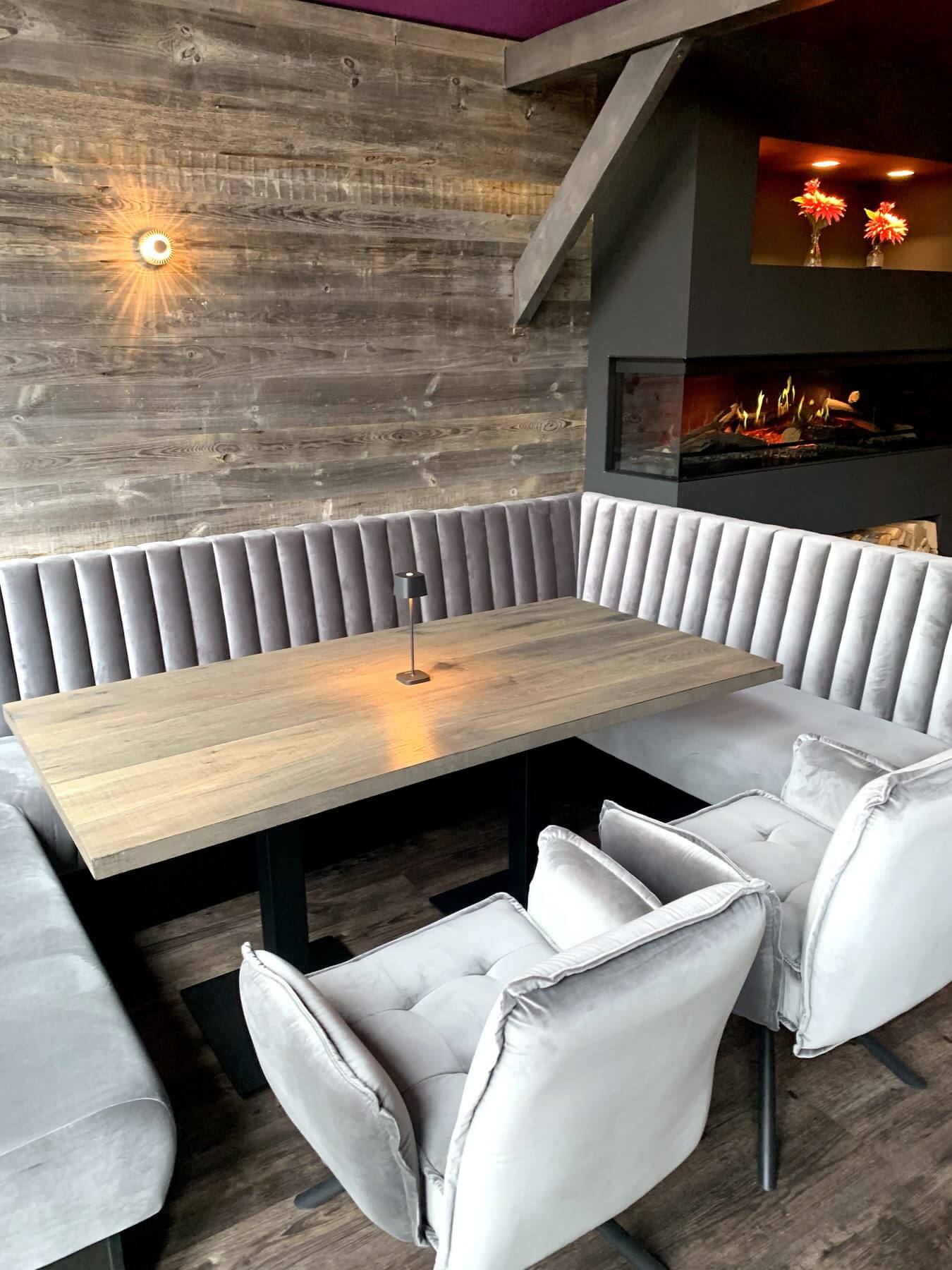 ar- und Loungebereich im Die2 Neubiberg mit heller Polsterbank, Holztisch und Sesselgruppe